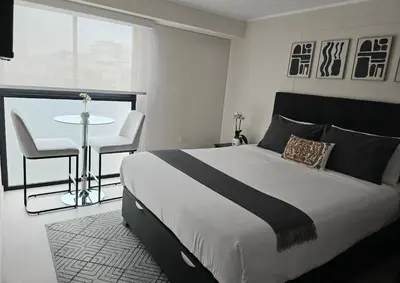 a bedroom with a bed and a table and chairs at Apartment suite in the heart of Miraflores! in Lima