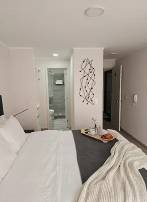 a bedroom with a large white bed with a tray on it at Apartment suite in the heart of Miraflores! in Lima