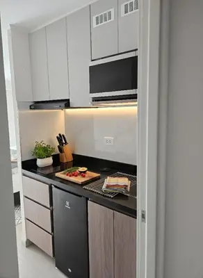 a kitchen with white cabinets and a stove top oven at Apartment suite in the heart of Miraflores! in Lima