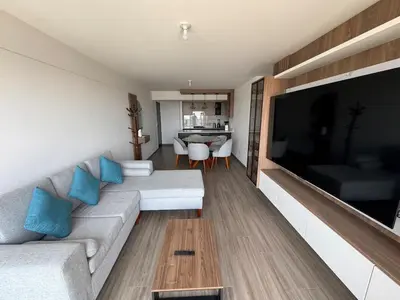 a living room with a couch and a large flat screen tv at Cozy bedroom in Miraflores with rooftop pool in Lima