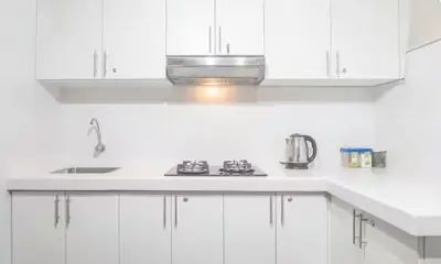 a white kitchen with white cabinets and a stove at Corazón de Cusco 2 in Cusco