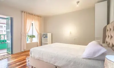a bedroom with a white bed and a window at Corazón de Cusco 2 in Cusco