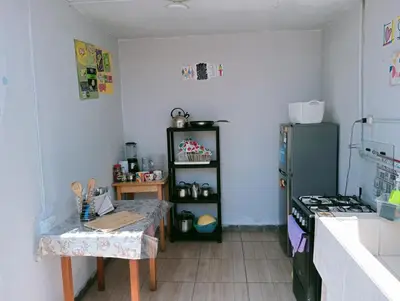 a kitchen with a table and a refrigerator at 4th Youth Loft Private Open Terrace Close Beach in Lima