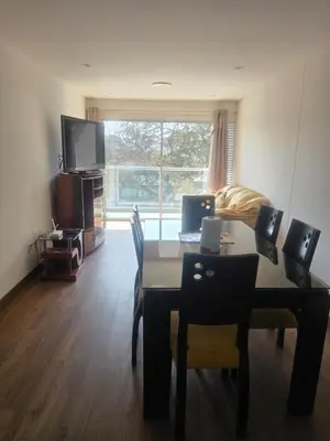 a living room with a table with chairs and a dining room at Departamento equipado, cómodo, tranquilo y céntrico in Lima