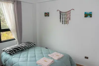 a bedroom with a bed with two towels on it at Valle Sagrado Mágico in Urubamba