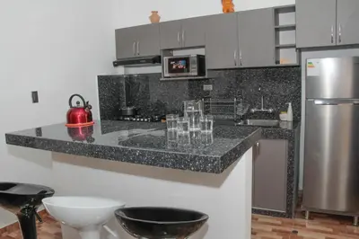 a kitchen with a granite counter top and a refrigerator at Valle Sagrado Mágico in Urubamba