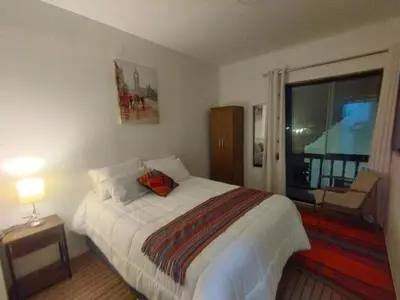 a bedroom with a large bed and a window at Maruri Valentino apartment in Cusco
