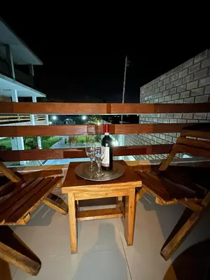 a wooden picnic table with a bottle and glasses on it at La Fogata del Sur in Asia