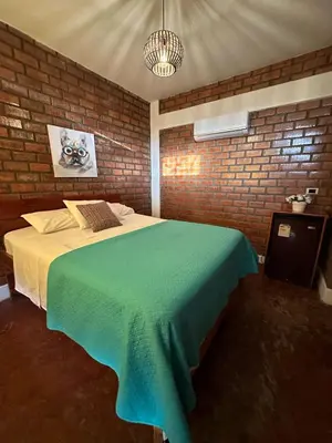a bedroom with a bed in a brick wall at La Fogata del Sur in Asia