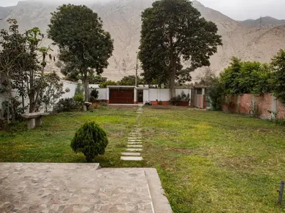 a yard with a house with mountains in the background at Cieneguilla Casa in Cieneguilla