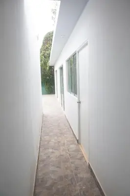 a hallway of a white building with a tile floor at Cieneguilla Casa in Cieneguilla