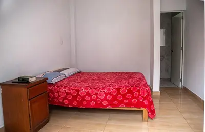 a bedroom with a red bed with a wooden dresser at Cieneguilla Casa in Cieneguilla
