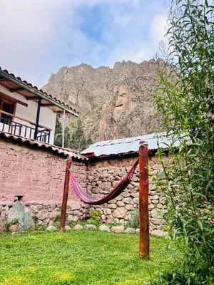 a house with a hammock in front of a building at Stone house in Ollantaytambo in Ollantaytambo