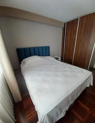 a bed with a blue headboard in a room at los hirukus cusco in Cusco