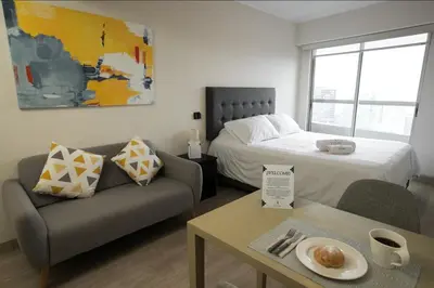 a living room with a bed and a couch at iStay Acogedor Loft Piscina BBQ Gym Bicicleta in Lima