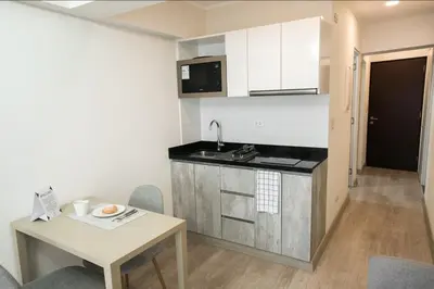 a small kitchen with a table and a sink at iStay Acogedor Loft Piscina BBQ Gym Bicicleta in Lima