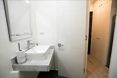 a white bathroom with a sink and a mirror at iStay Acogedor Loft Piscina BBQ Gym Bicicleta in Lima