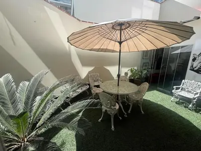 a table and chairs with an umbrella in a room at Comfortable apartment in downtown area - 3 bedrooms in Lima