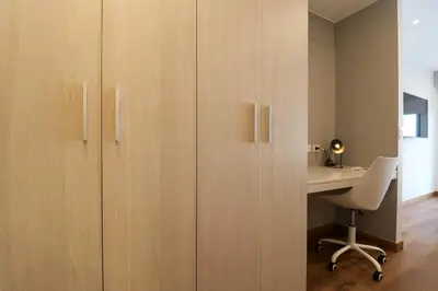 an office with wooden cabinets and a desk with a chair at Schell in Miraflores by Wynwood House in Lima