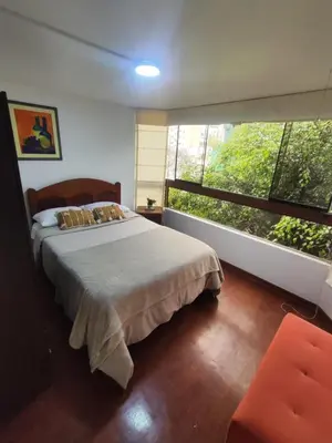 a bedroom with a bed and a large window at Céntrica habitación con vistas Larcomar in Lima