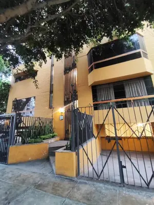 a yellow building with a gate in front of it at Cómoda y céntrica habitación Larcomar in Lima