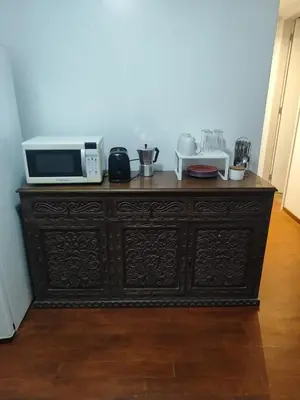 a wooden cabinet with a microwave on top of it at Amplia y céntrica habitación con vistas Larcomar in Lima