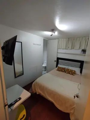 a small room with a bed and a mirror at Acogedora y céntrica habitación Larcomar in Lima