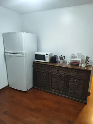 a kitchen with a refrigerator and a microwave on a dresser at Acogedora y céntrica habitación Larcomar in Lima