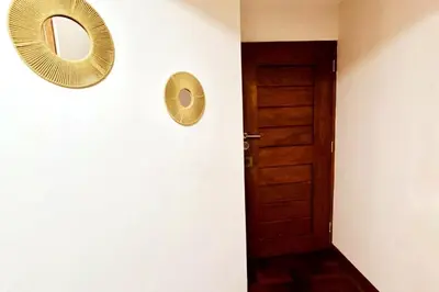 a hallway with a door and two mirrors on the wall at Departamento en Cusco NAIRA in Cusco