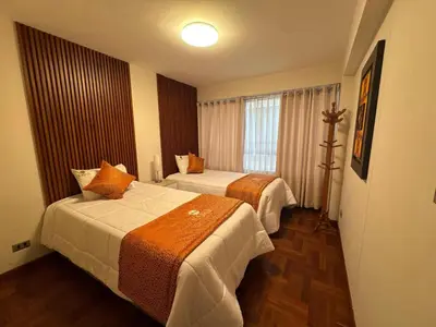 a hotel room with two beds and a window at Departamento en Cusco NAIRA in Cusco