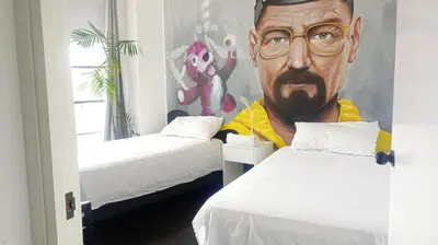 a room with two beds with a painting of a man at PintoHome in Lima