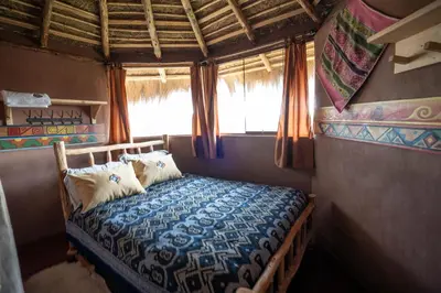 a bedroom with a bed in a room with a window at Pachamama Hampina Wasi Ancestral Center in Urubamba