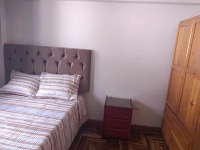 a bedroom with a bed and a night stand next to it at El despertar del inka in Cusco