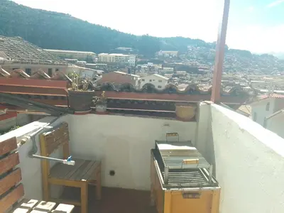 a balcony with two chairs and a view of a city at El despertar del inka in Cusco