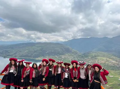 a group of girls in traditional dress standing on a mountain at Cabañas lago piuray in Chinchero