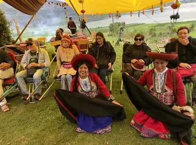 a group of people sitting in chairs under a tent at Cabañas lago piuray in Chinchero