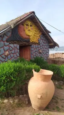 a house with a vase in front of it with a face painted on it at Cabañas lago piuray in Chinchero
