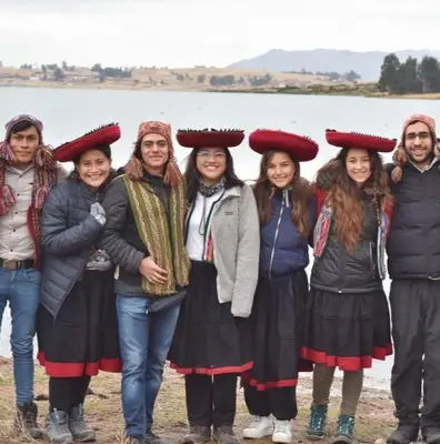 a group of people standing in front of a body of water at Cabañas lago piuray in Chinchero