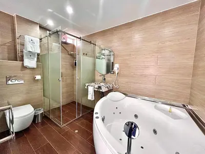 a bathroom with a tub and a shower and a toilet at Hotel BlueThree Chancay in Chancay