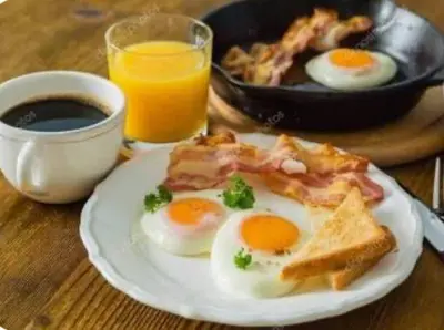 a plate of eggs and toast and a glass of orange juice at Hotel BlueThree Chancay in Chancay