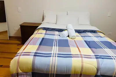 a bed with a multicolored blanket on it at Habitación Acogedora con Baño Privado y Entrada Propia en Miraflores in Lima