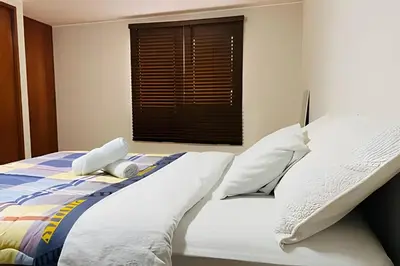 a bedroom with a bed with white sheets and a window at Habitación Acogedora con Baño Privado y Entrada Propia en Miraflores in Lima