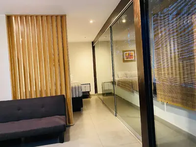 a living room with a couch and a bedroom at Tu Refugio en Miraflores – Céntrico y Tranquilo in Lima