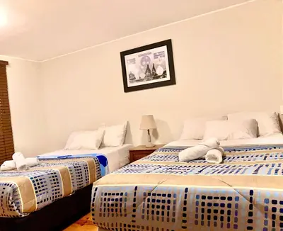 a room with two beds and a picture on the wall at Suite Independiente con Baño Privado – Miraflore in Lima