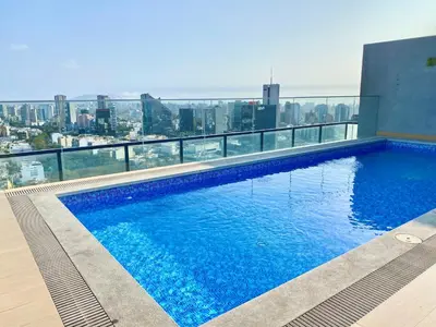 a swimming pool on the roof of a building at Apartamento con vista a San Isidro in Lima