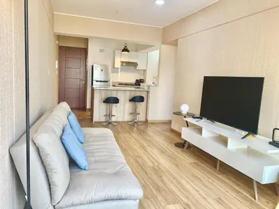 a living room with a white couch and a flat screen tv at Apartamento con vista a San Isidro in Lima
