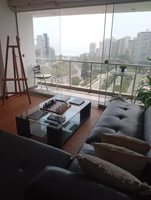 a living room with a couch and a glass table at Large Oceanview Balcony Apartment in Miraflores in Lima