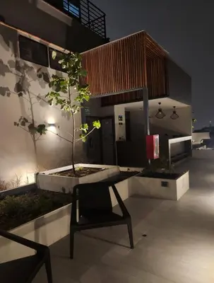 a chair sitting in front of a building with a tree at Elegante Departamento de Estreno en Centro Financiero in Lima