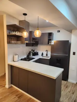 a kitchen with a white counter and a black refrigerator at Elegante Departamento de Estreno en Centro Financiero in Lima