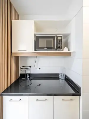 a kitchen with a microwave and a black counter top at Central Bloom Miraflores in Lima